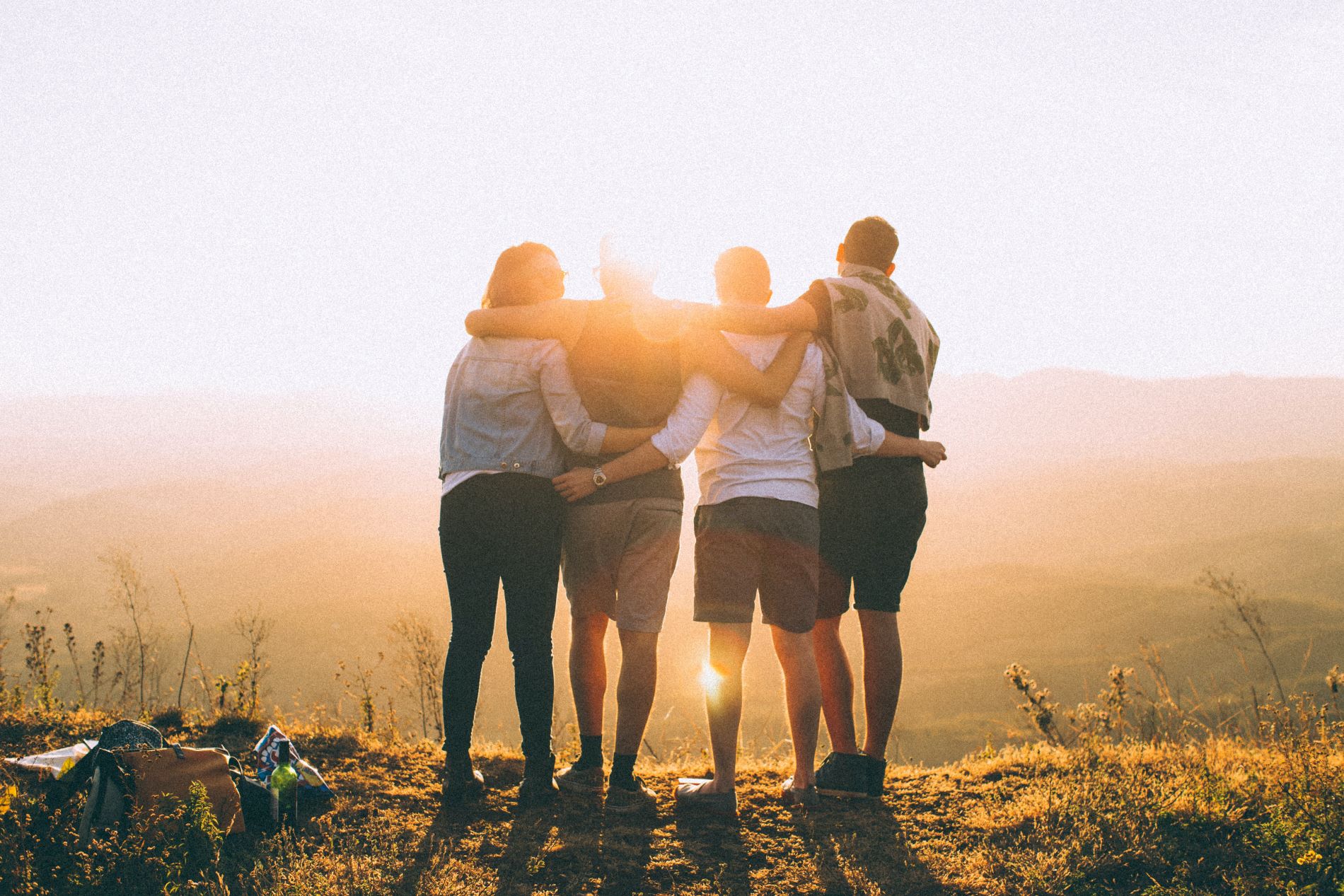 Group of people looking over landscape into the sun