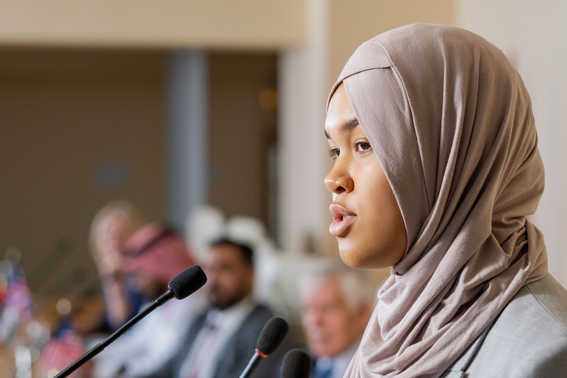 female speaker in hijab talking into a microphone