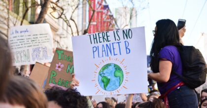Climate activist holding a sign which reads 'There is no planet b' loading=